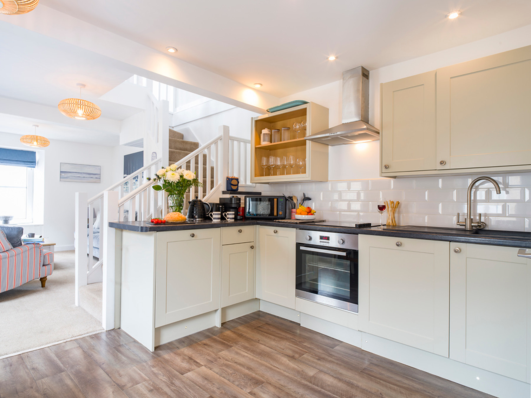 Fitted kitchen with cream units, oven, hob and extractor hood