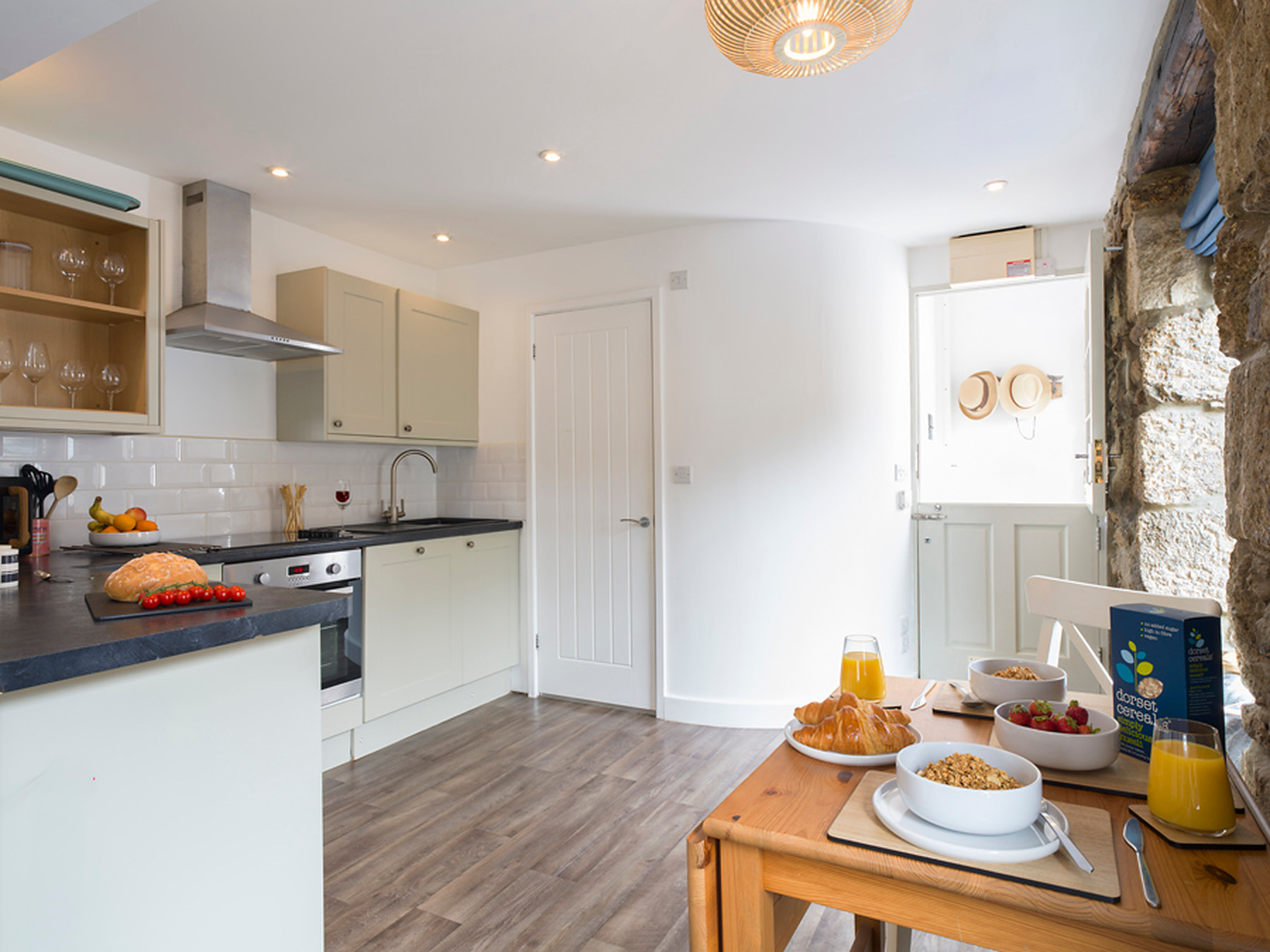Kitchen and dining table set for breakfast with juice and pastries