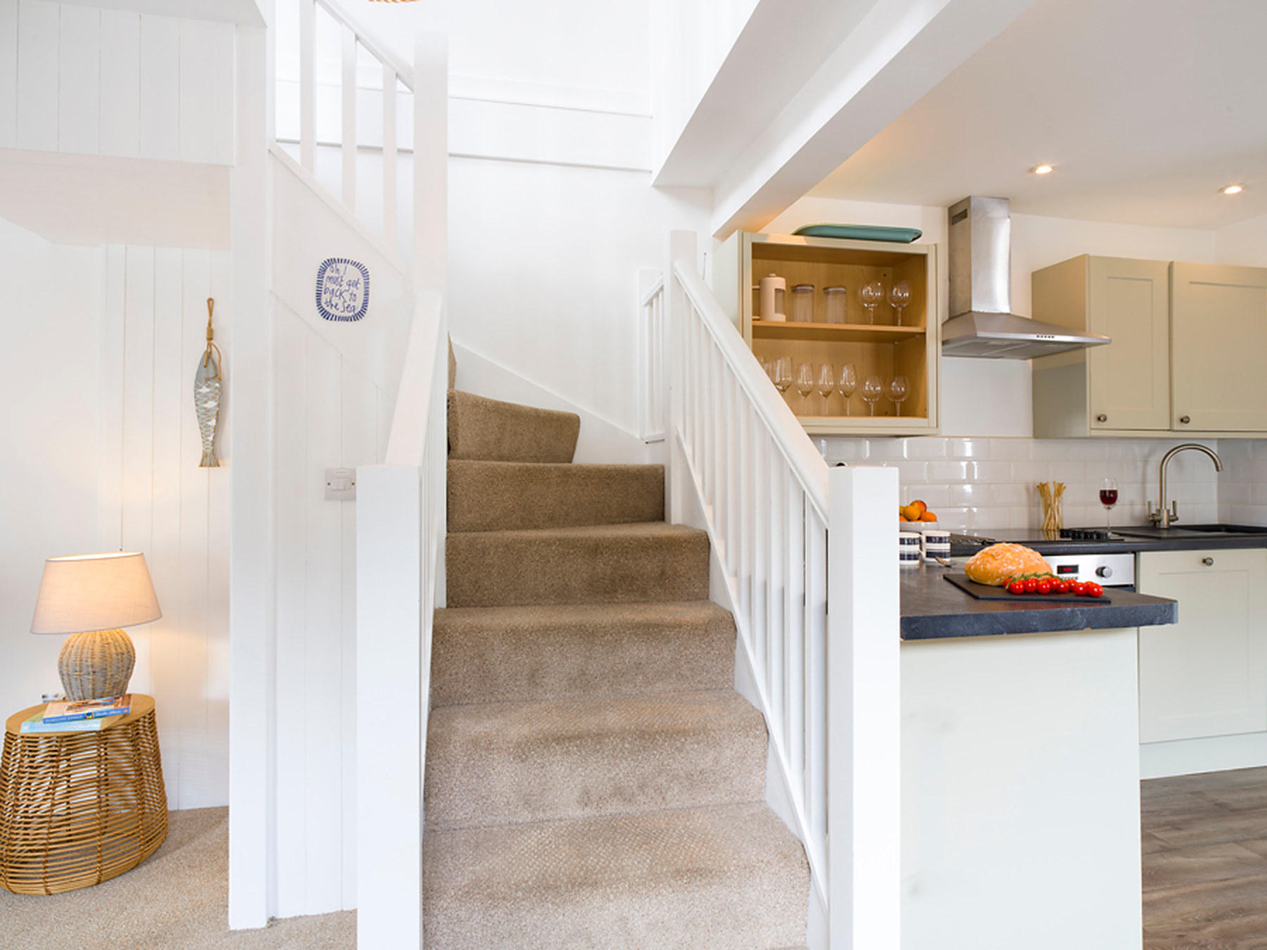 Carpeted staircase leading up from the kitchen to the bedroom